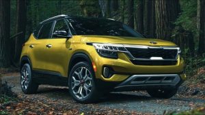 A yellow 2022 Kia Seltos driving in the woods.