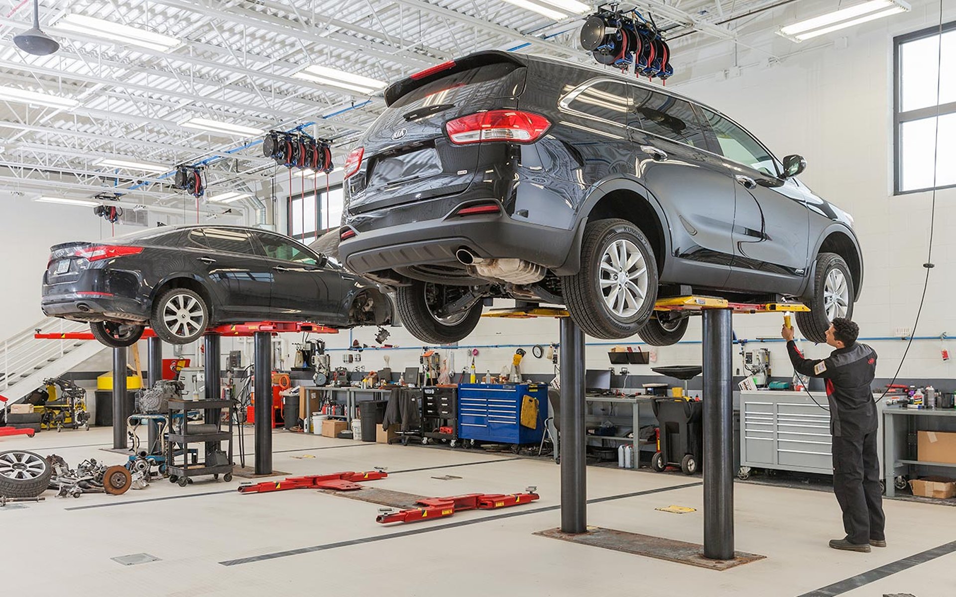 Service advisors performing a brake repair on a Kia vehicle