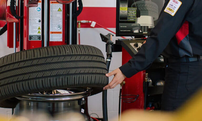 Kia technician working on a tire
